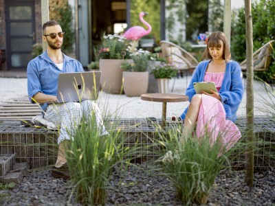 Gartenversicherung: Ein Paar sitzt auf der Terrasse mit Garten.