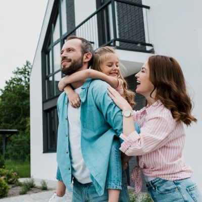 Junge Familie mit Kind stehen vor Ihrem neuen zu Hause